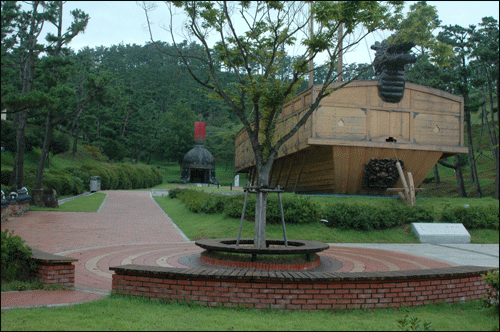 당항포관광지에서, 거북선의 모형과 뒤로 이순신장군의 투구모형이 보인다 